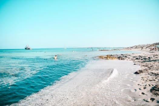 Relaxační plážová scéna na Formenteře ve Španělsku s průzračně modrými vodami a klidným horizontem.