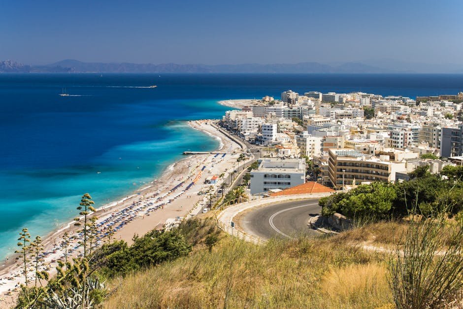 Stunning aerial view of Rhodes, Greece with its beautiful beach and vibrant cityscape under a clear blue sky.