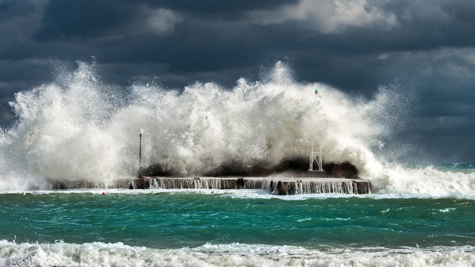 Kréta pro páry y rodiny | co dělat a vidět na dovolené 3 Dramatic ocean waves crashing against a concrete structure in Pantanassa, capturing nature's raw power.