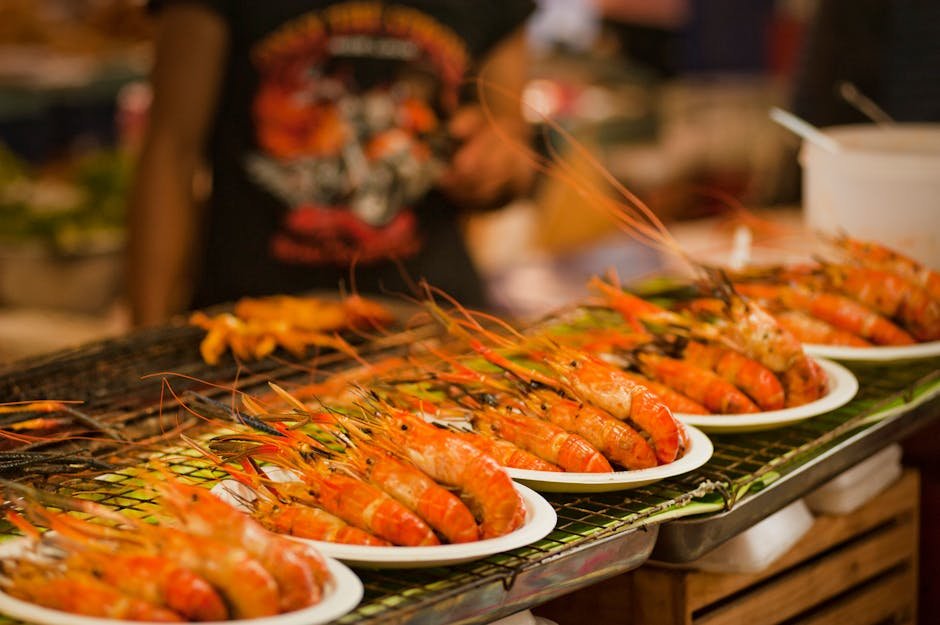 Mallorca | Dovolená v Bahia Principe Sunlight Coral Playa 6 Deliciously grilled shrimps on plates ready to serve at a vibrant Bangkok street food market.