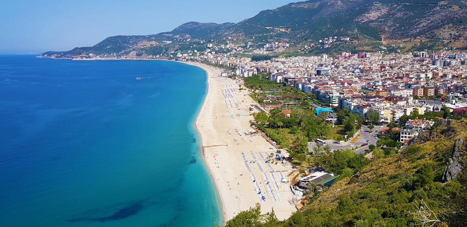 Scenic aerial view of Alanya, Turkey, showcasing vibrant coastline and mountainous backdrop.