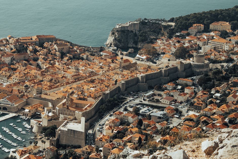 Explore Dubrovnik's historic Old Town from above, showcasing its iconic medieval walls and stunning Adriatic coastline.