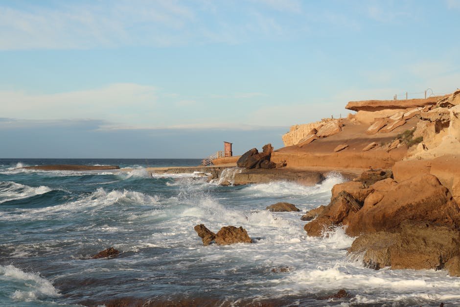Capture of rocky cliffs and turbulent sea waves at Ibiza's coast during sunset, showcasing natural beauty.