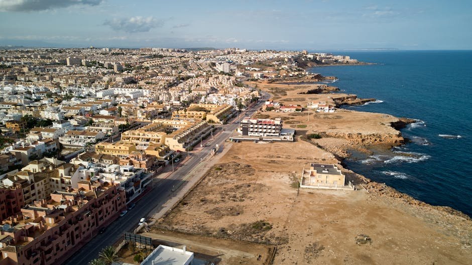 Drone shot of Torrevieja, Spain showcasing cityscape and coastline against the sea.