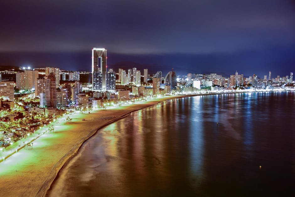 Explore the vibrant nighttime skyline of Benidorm's beachfront with illuminated skyscrapers.