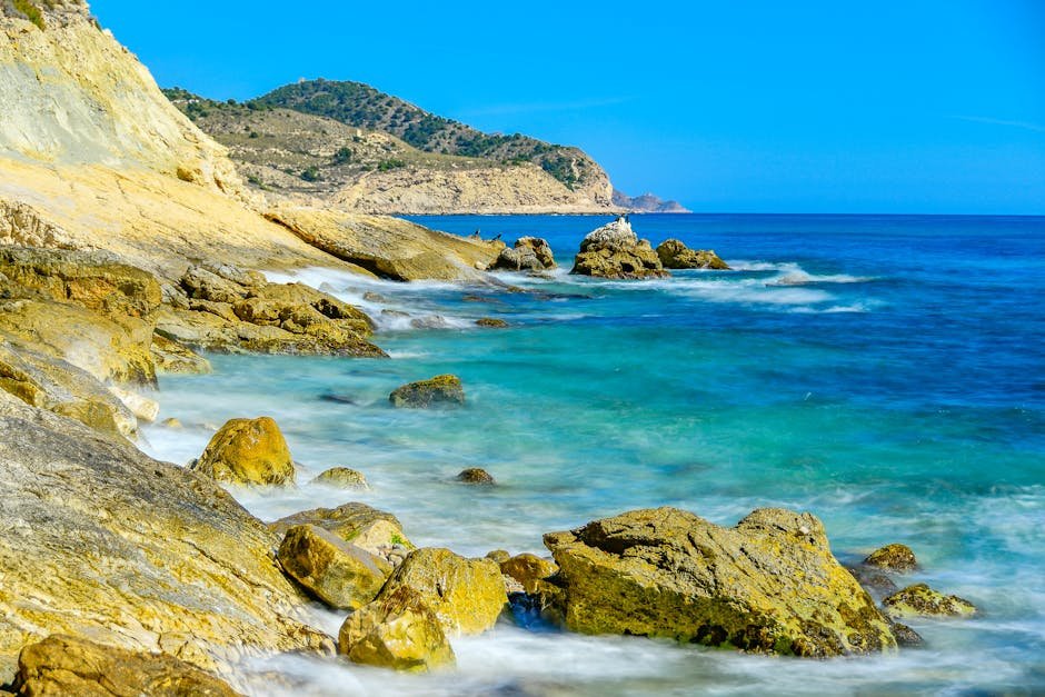 Breathtaking view of the rocky coastline in Villajoyosa, Spain with clear blue water and dramatic landscapes.
