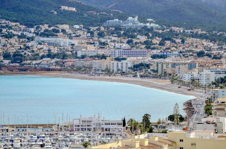 Aerial view of Altea's coastline and marina under a clear sky, showcasing its vibrant architecture.