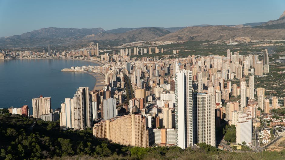 Amazing cityscape of Benidorm with modern buildings and skyscrapers located near sea beach under cloudless blue sky