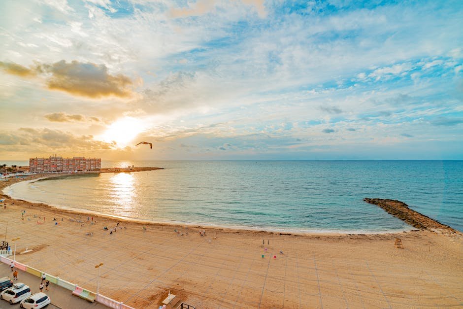 A breathtaking view of Torrevieja beach at sunset with golden hues and calm sea.