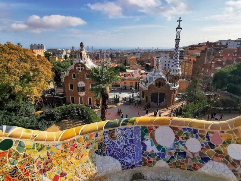 A colorful mosaic and architectural view of Park Güell in Barcelona, showcasing Gaudí's unique style.
