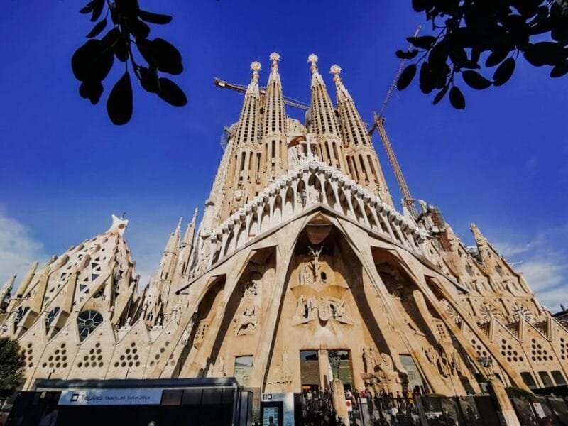 Stunning view of Sagrada Familia's intricate facade against a blue sky in Barcelona.