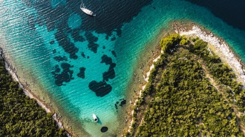 Stunning aerial shot of Croatia's coastline with clear turquoise waters and lush greenery.