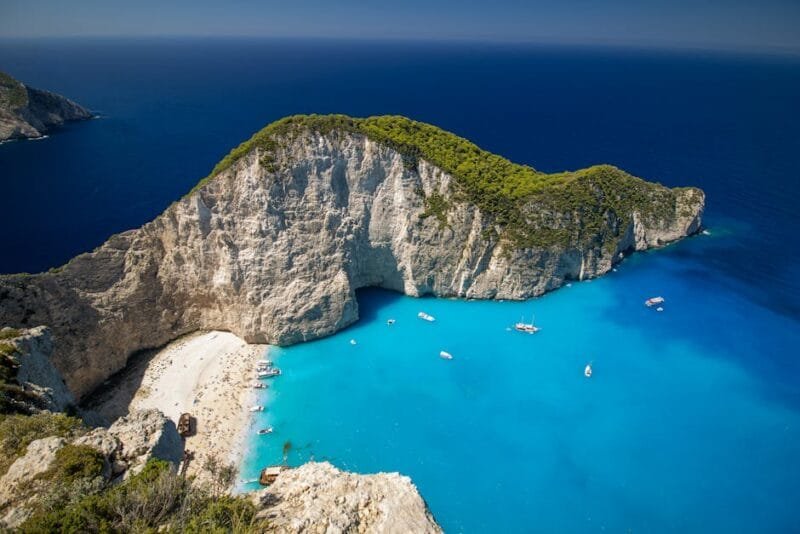 Le Cose da Fare in Grecia | Antichità, Spiagge e Avventura 1 Stunning aerial view of Navagio Beach on Zakynthos Island, Greece, with azure waters and surrounding cliffs.