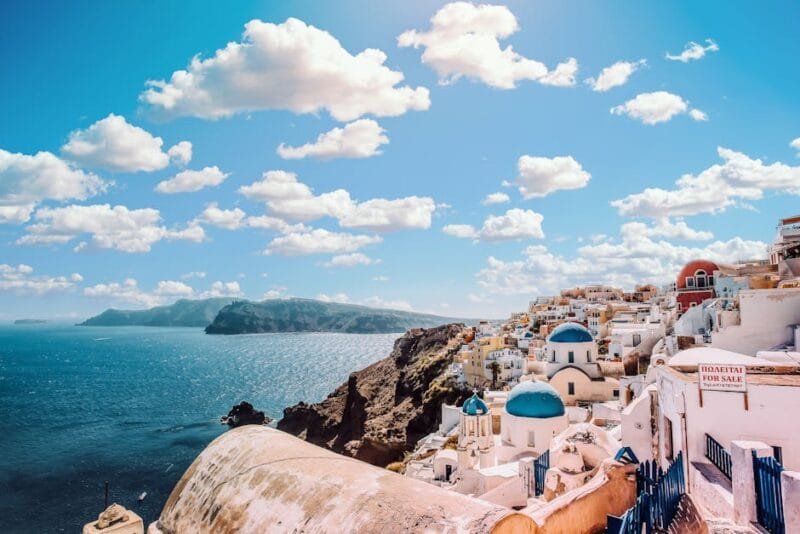 Mykonos | Migliori Destinazioni e Attività per Vacanze 1 Captivating view of Santorini's famous blue-domed buildings under a vibrant sky.