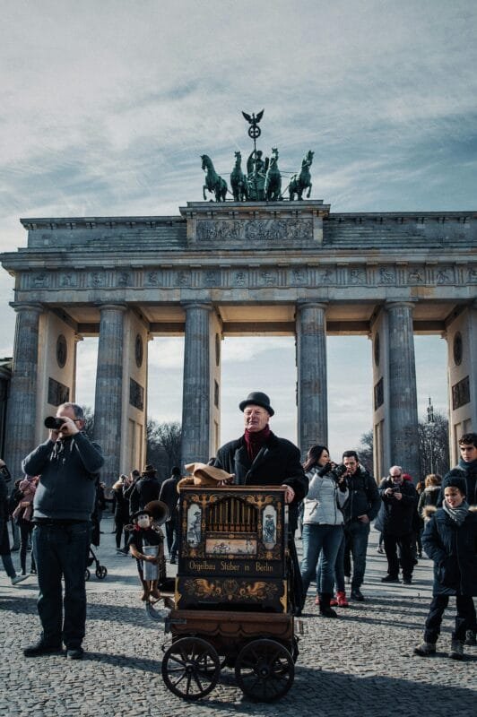 pexels photo 1963081 1963081 Street performer at Berlin's iconic Brandenburg Gate, engaging the crowd with a unique musical instrument.