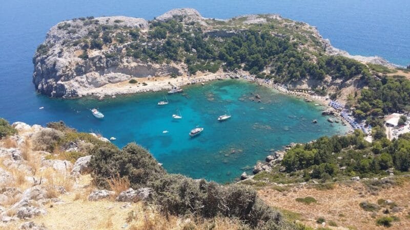 Le Cose da Fare in Grecia | Antichità, Spiagge e Avventura 3 A stunning aerial view of a turquoise lagoon surrounded by rocky cliffs and lush greenery, ideal for travel enthusiasts.