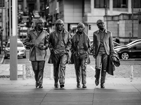 Black and white image of Beatles statues on a street in Liverpool, England.