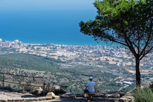 Person enjoying panoramic view of Benalmádena and Mediterranean coastline from Mount Calamorro.