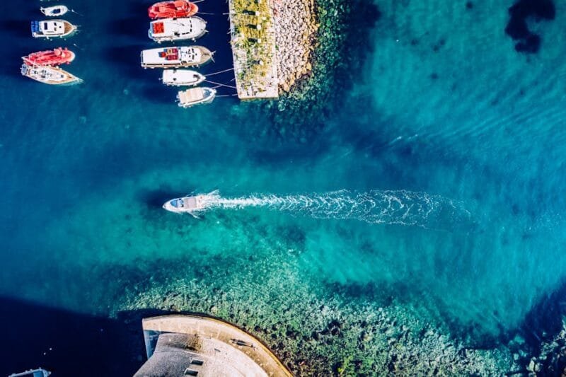 Stunning aerial view of boats and clear turquoise waters along the Adriatic coast in Dubrovnik, Croatia.