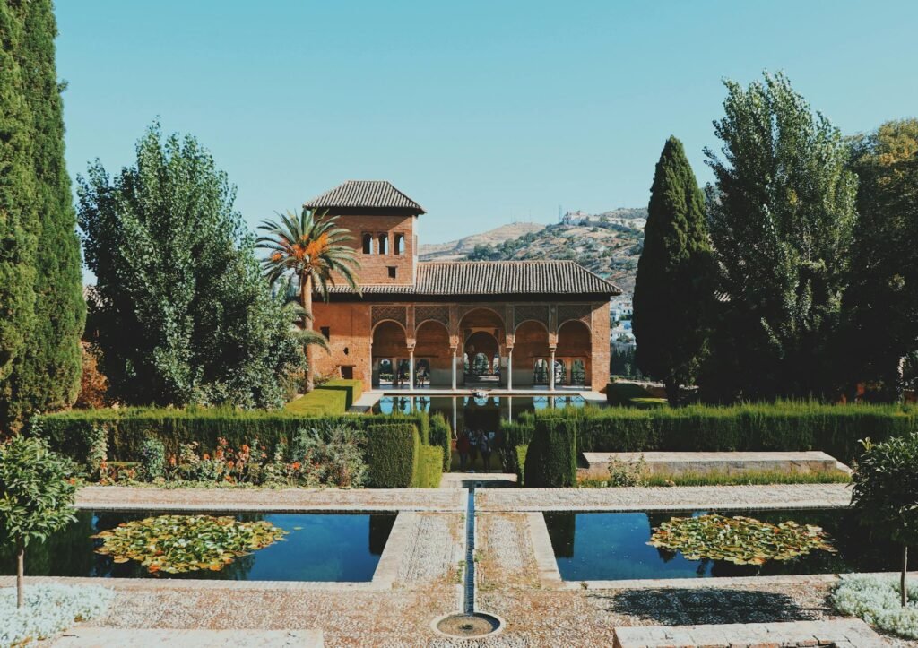 pexels photo 20455327 20455327 Beautiful view of El Partal in Alhambra, Granada, featuring lush gardens and reflective pools.