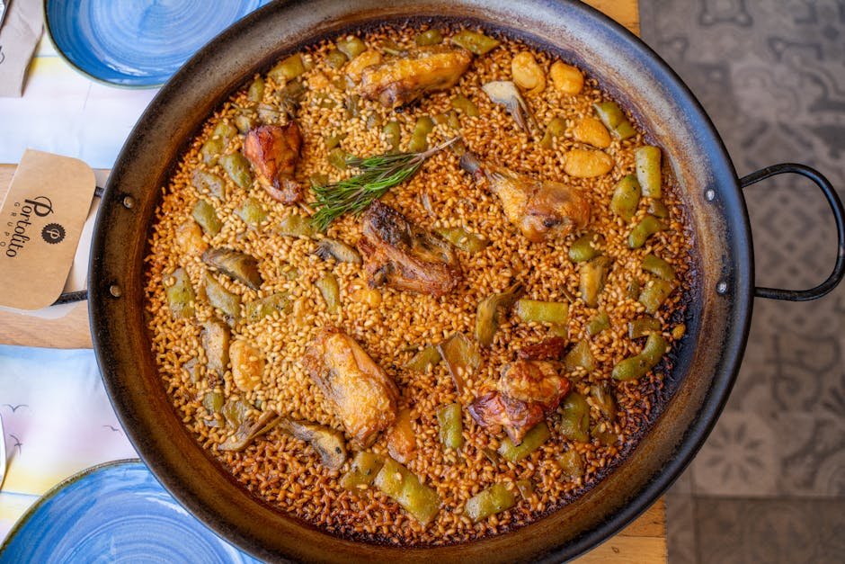Valencia | atrakcie a miesta, ktoré nesmieš vynechať 3 Authentic Valencia paella in a pan with chicken, vegetables, and rosemary. Top view.