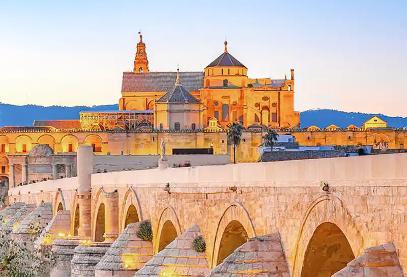 foto de puente romano en cordoba, con la catedral de cordoba en el fondo
